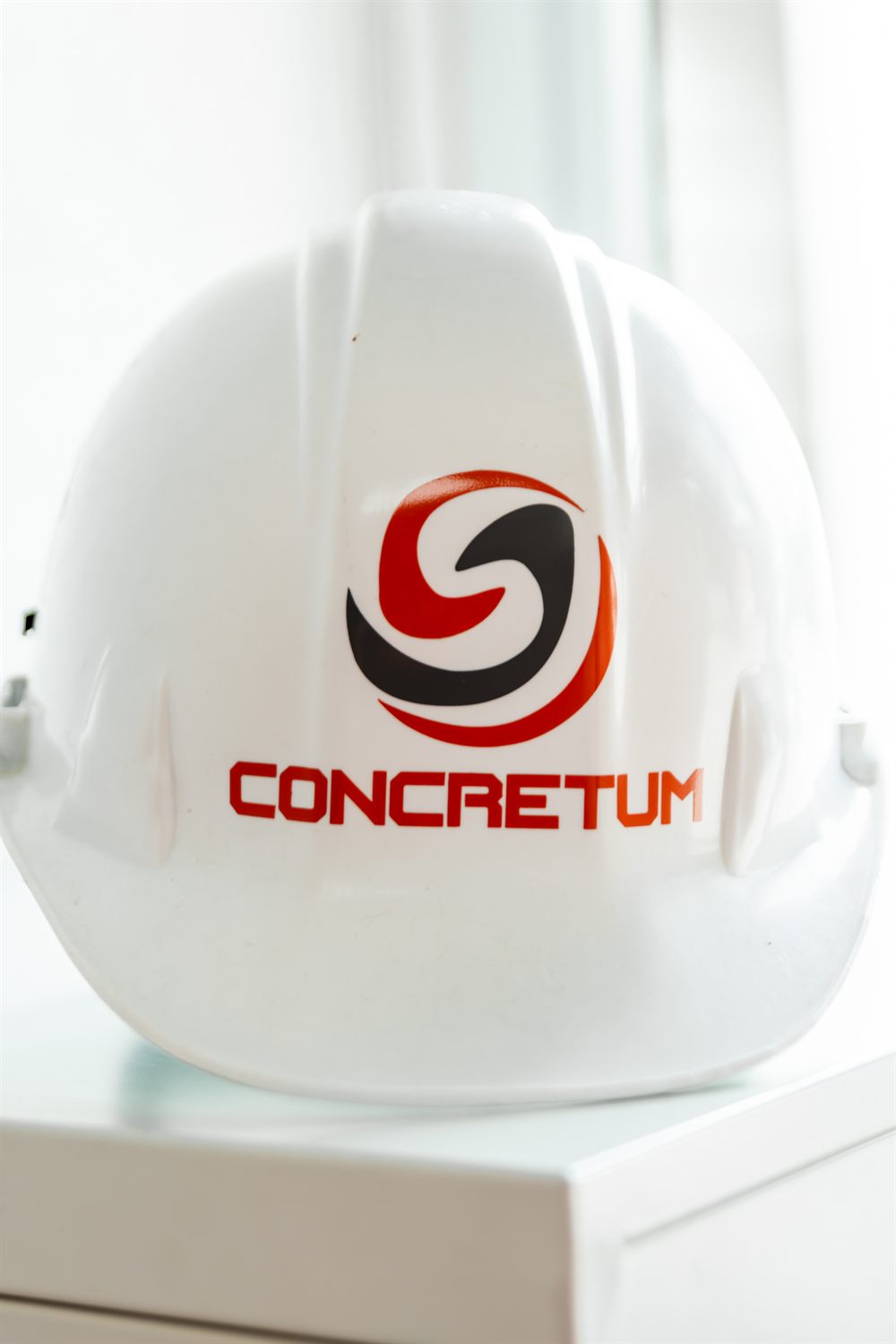 Casco de seguridad con el logo de CONCRETUM en obra