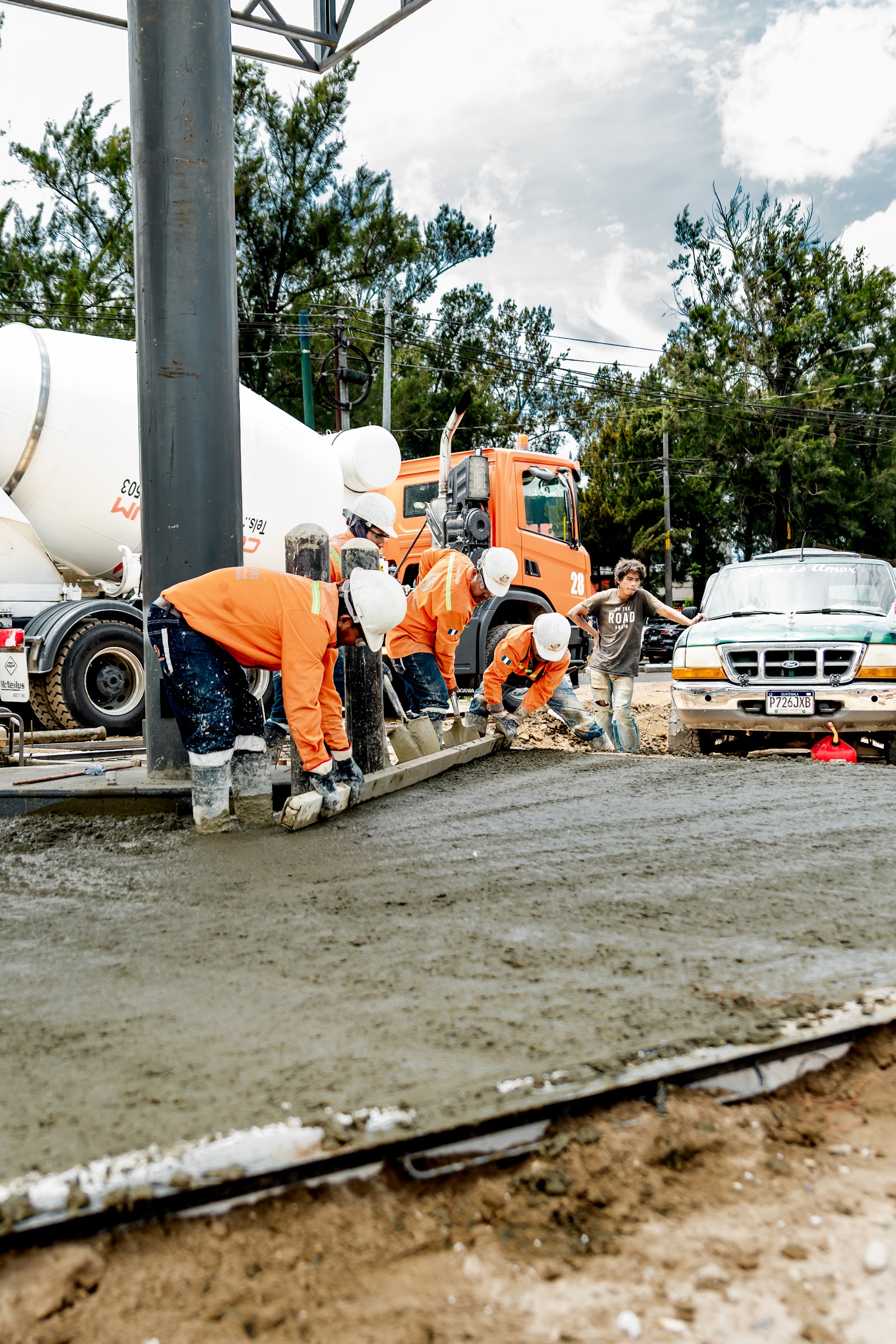 Camión mezclador y cuadrilla de CONCRETUM colocando concreto